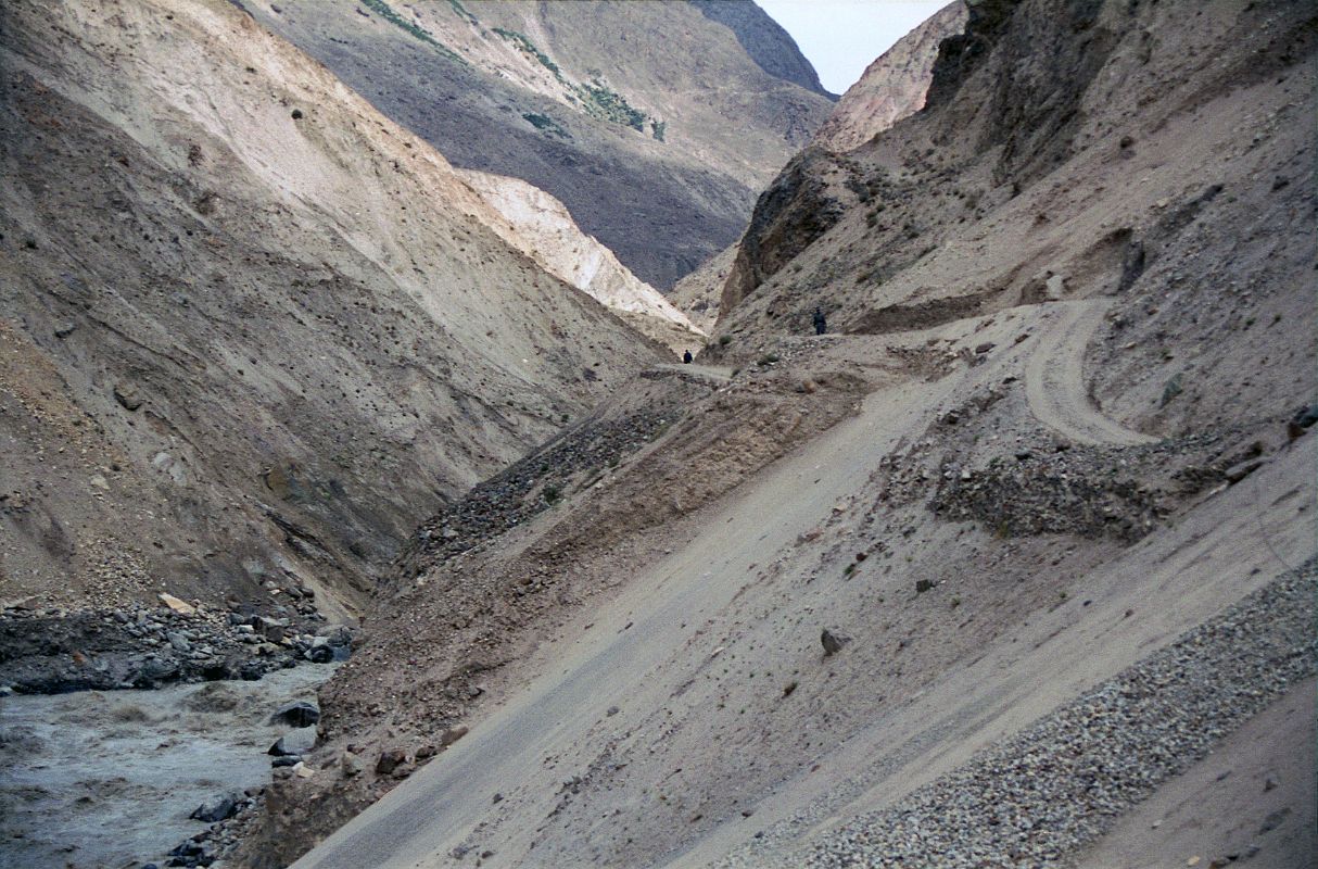 08 Road Though Braldu Gorge To Askole Slants Dangerously Towards The Roaring Braldu River On our seven-hour 117km jeep ride from Skardu to the trailhead at Thongol (2850m), we drove through the 40km Braldu Gorge, where the road is blasted out of the rocks next to the roaring Braldu River. The sickeningly narrow gravel road sometimes slants dangerously towards the Braldu River. You have to withstand being scared constantly for two hours with your life clearly in your drivers eyes, hands and feet. 'Oh well', I thought. The scariest thing for me was when the jeep had to do three-point turns around hairpin curves. He'd get to the edge with the foaming Braldu River hundreds of metres below, and then reverse back up the hill. 'I hope he knows the reverse gear', I think to myself.